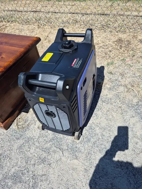 A portable generator standing beside a polished timber blanket box.